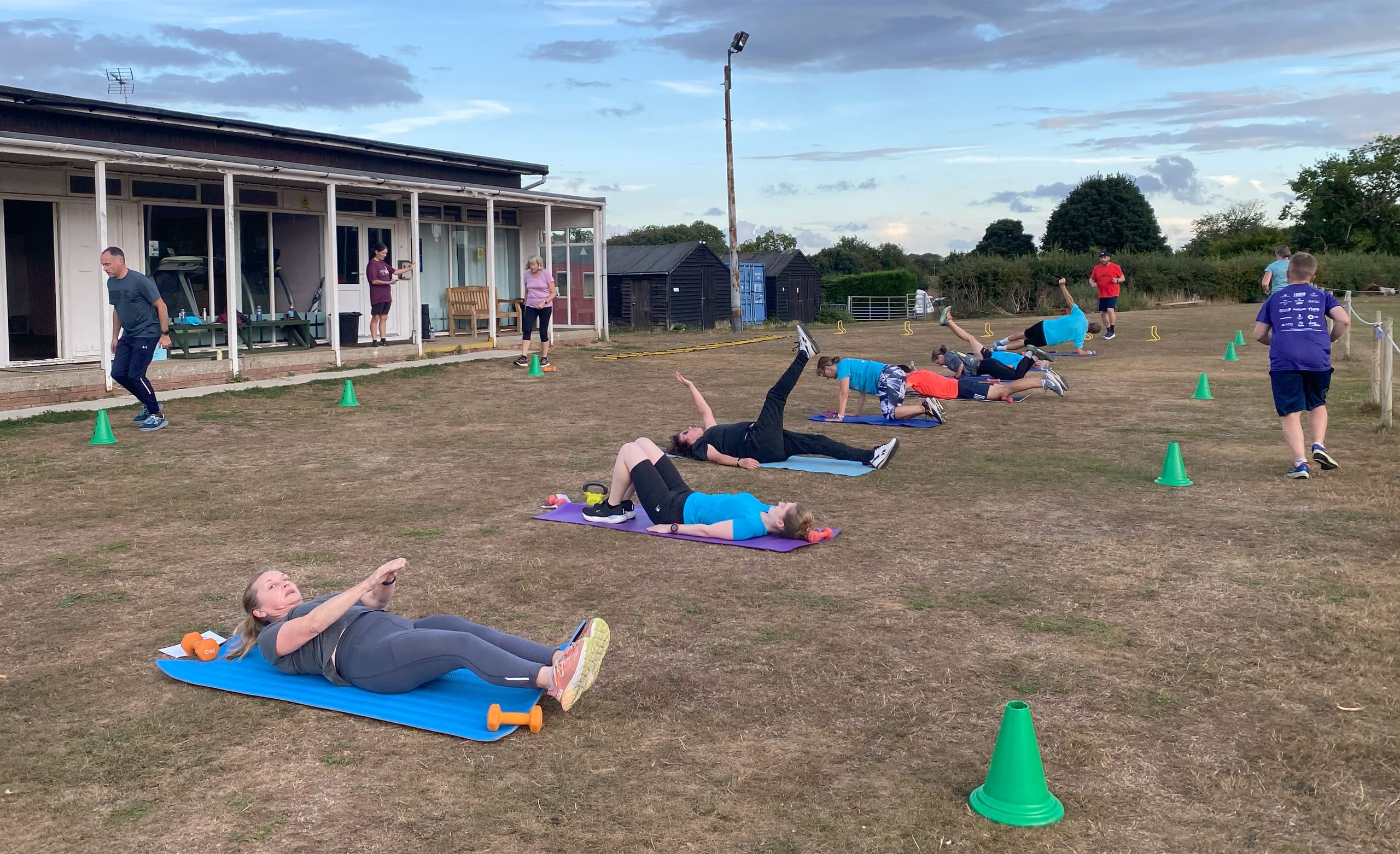 Strength session Line of people exercising on the grass