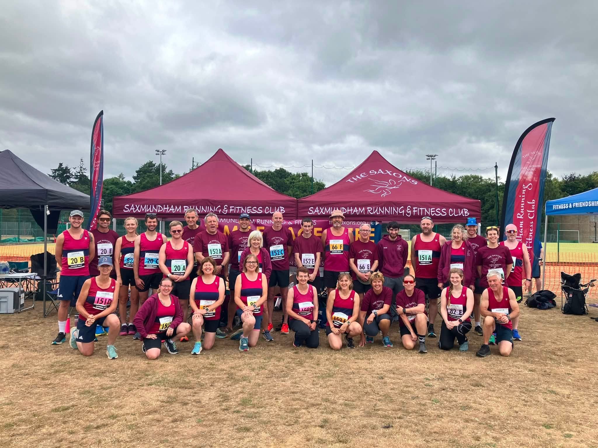 Group of runners wearing purple tops stood infront of a gazebo